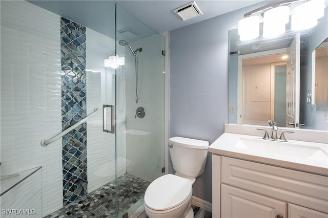 bathroom with a stall shower, vanity, toilet, and visible vents