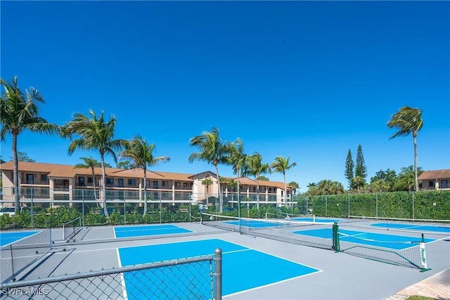 view of pool with fence and a tennis court