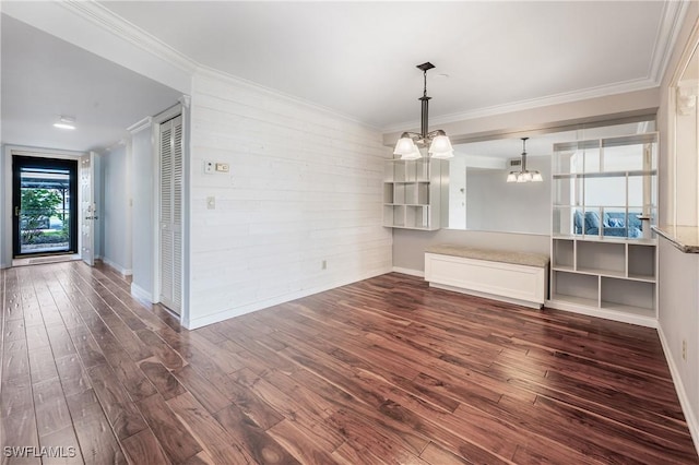 unfurnished dining area with a chandelier, dark wood-style flooring, baseboards, and ornamental molding