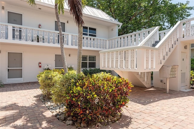 780 10th Ave S Unit 23, Naples, FL 34102 - exterior space featuring stairway, a standing seam roof, metal roof, and stucco siding