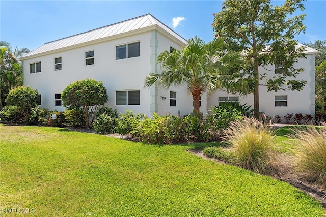 780 10th Ave S Unit 23, Naples, FL 34102 - back of house featuring a lawn, stucco siding, metal roof, and a standing seam roof