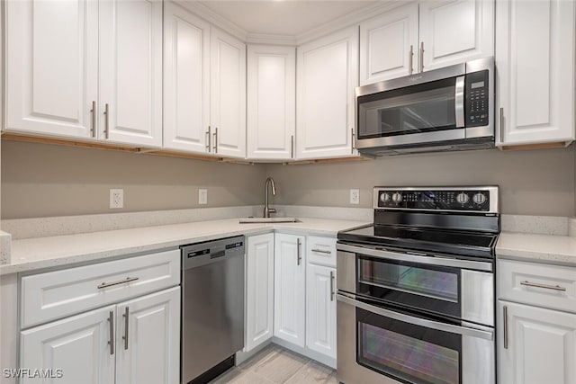 780 10th Ave S Unit 23, Naples, FL 34102 - kitchen with stainless steel appliances, light stone countertops, white cabinetry, and a sink