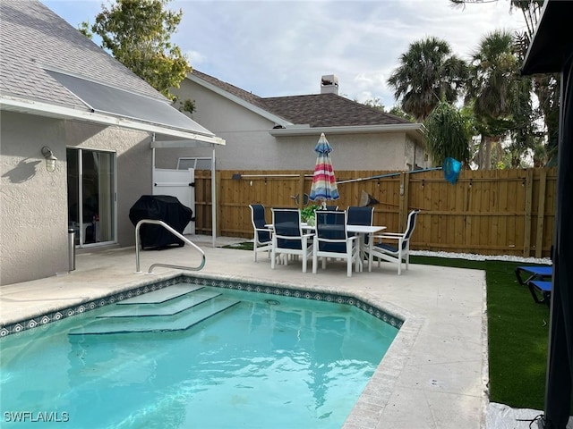 view of pool with fence, a fenced in pool, a patio area, and area for grilling