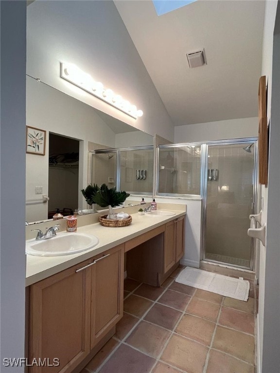 full bathroom featuring a sink, vaulted ceiling, a stall shower, and double vanity