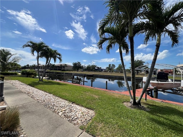 1016 SE 46th St Unit 102, Cape Coral, FL 33904 - dock area with a yard, boat lift, central AC, and a water view