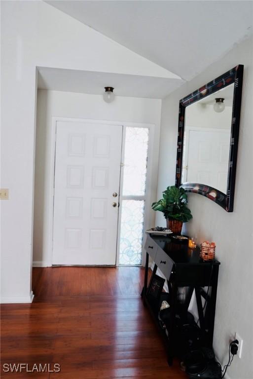 6053 Timberwood Cir Unit 233, Fort Myers, FL 33908 - entrance foyer featuring baseboards, wood finished floors, and vaulted ceiling