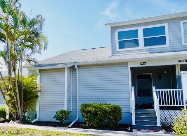 6053 Timberwood Cir Unit 233, Fort Myers, FL 33908 - view of front of property featuring a shingled roof and covered porch