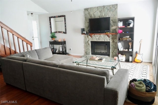 6053 Timberwood Cir Unit 233, Fort Myers, FL 33908 - living room featuring a stone fireplace, baseboards, wood finished floors, vaulted ceiling, and stairway