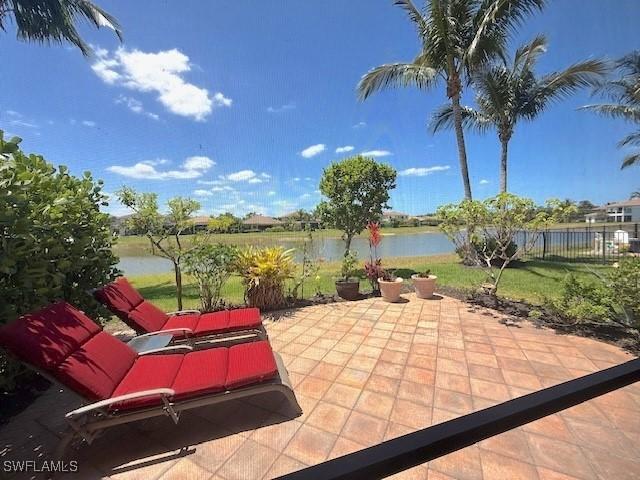 view of patio / terrace featuring a water view and fence