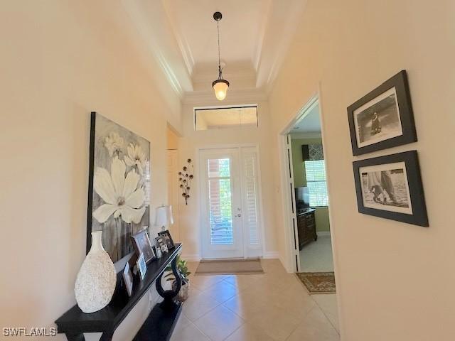 entrance foyer with tile patterned floors and ornamental molding