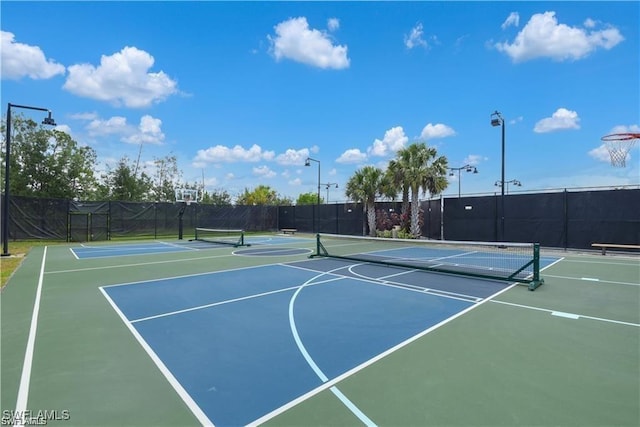 view of tennis court with fence and community basketball court