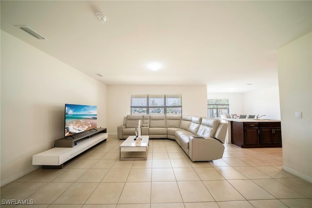 living room with visible vents, baseboards, and light tile patterned flooring