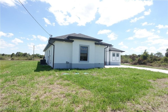 224 Preston St, Lehigh Acres, FL 33974 - view of front facade featuring stucco siding, a front lawn, and cooling unit