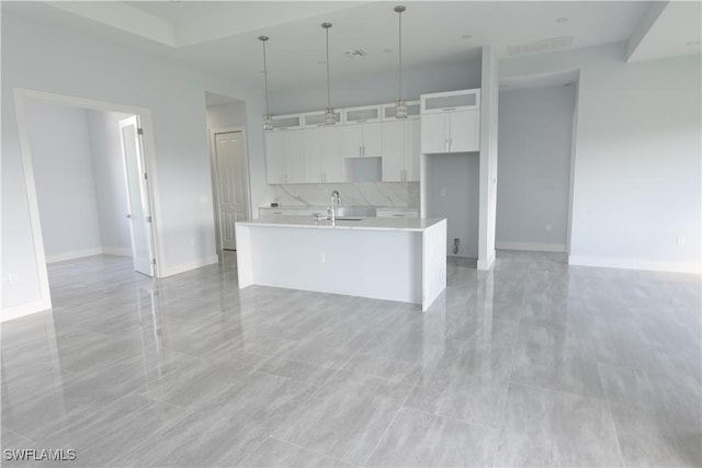 224 Preston St, Lehigh Acres, FL 33974 - kitchen with a sink, white cabinets, an island with sink, light countertops, and pendant lighting
