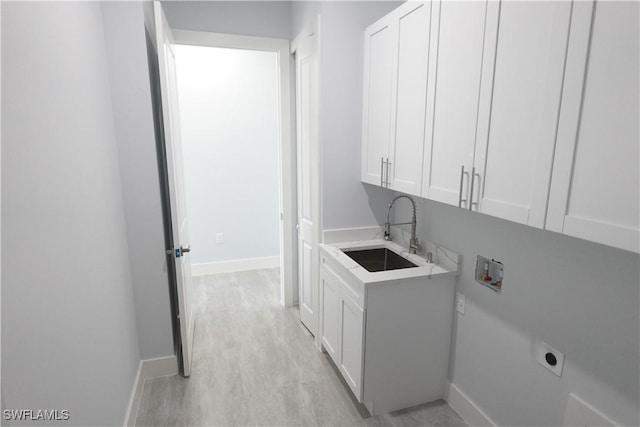 224 Preston St, Lehigh Acres, FL 33974 - laundry area featuring hookup for an electric dryer, cabinet space, baseboards, and light wood-style flooring