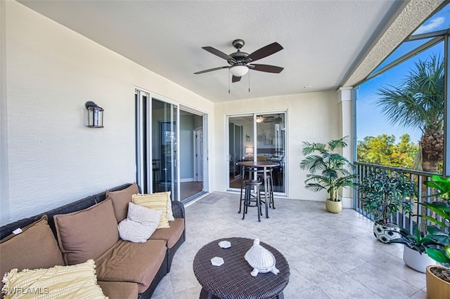 exterior space with a ceiling fan and a balcony