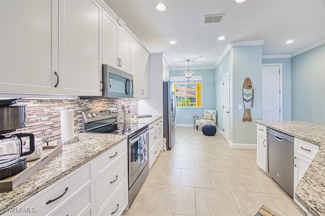 kitchen with white cabinets, appliances with stainless steel finishes, baseboards, tasteful backsplash, and ornamental molding