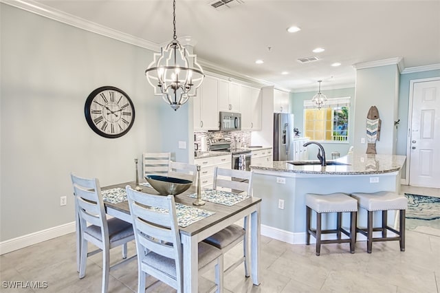 dining room with ornamental molding, visible vents, and a chandelier