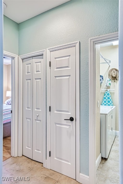 hallway featuring a textured wall and independent washer and dryer