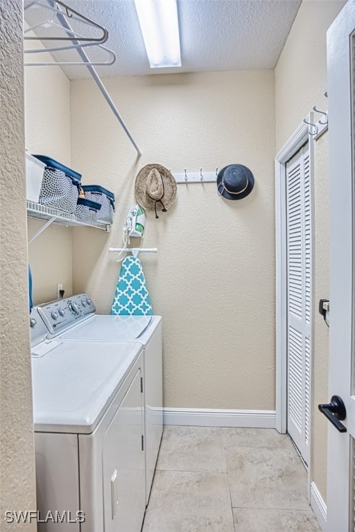 washroom featuring laundry area, a textured ceiling, independent washer and dryer, baseboards, and a textured wall
