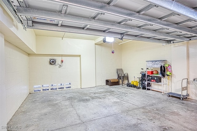 garage with concrete block wall and a garage door opener