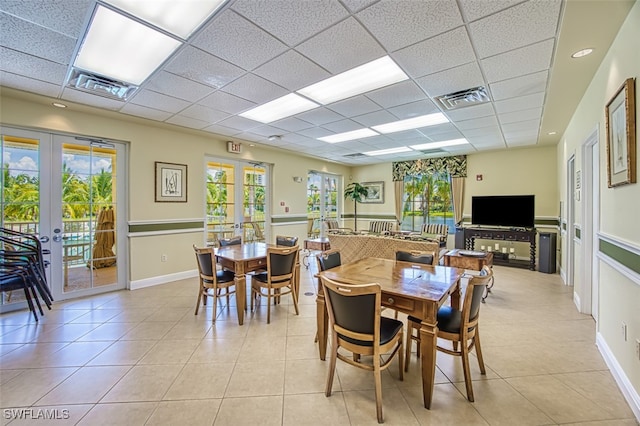dining area with french doors, a drop ceiling, light tile patterned flooring, and visible vents