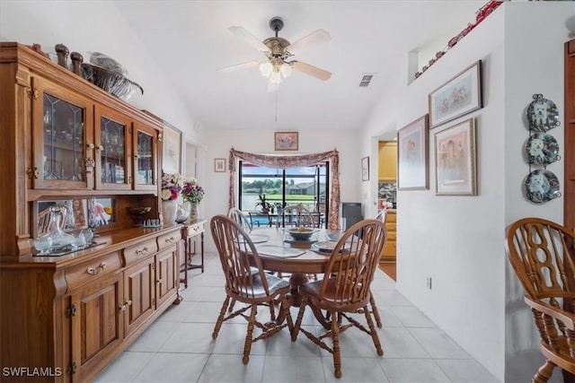 dining space featuring visible vents, a ceiling fan, light tile patterned flooring, and vaulted ceiling