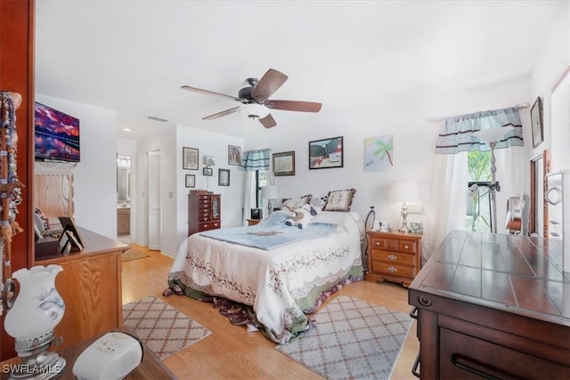 bedroom with light wood-style floors, ensuite bathroom, a ceiling fan, and recessed lighting
