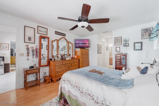 bedroom with visible vents, connected bathroom, light wood finished floors, and ceiling fan