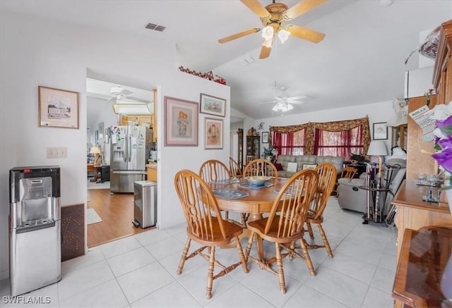 dining area with ceiling fan, visible vents, light tile patterned floors, and lofted ceiling