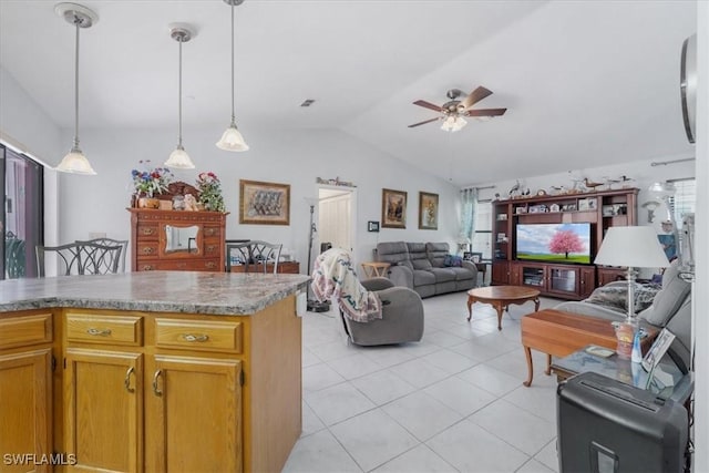 living room featuring a ceiling fan, vaulted ceiling, a healthy amount of sunlight, and light tile patterned floors