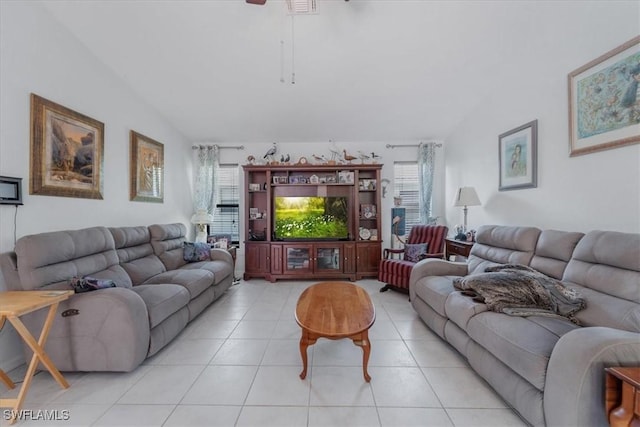 living room featuring light tile patterned floors, vaulted ceiling, and a ceiling fan