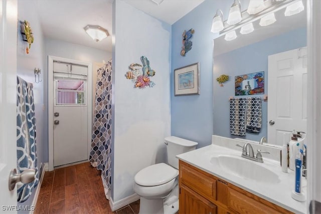 bathroom featuring vanity, toilet, wood finished floors, and a shower with shower curtain