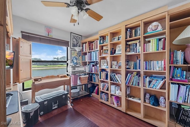 interior space featuring a water view, ceiling fan, and wood finished floors