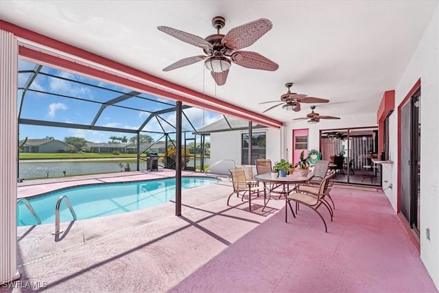 pool with glass enclosure, a patio, a water view, and a ceiling fan