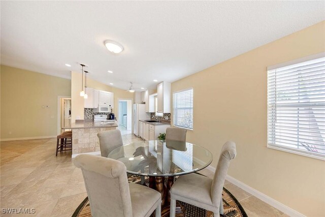 dining space featuring baseboards and light tile patterned floors
