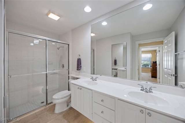 bathroom with a sink, a shower stall, toilet, and double vanity
