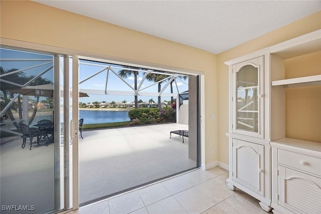 entryway featuring a water view, baseboards, light colored carpet, and light tile patterned flooring