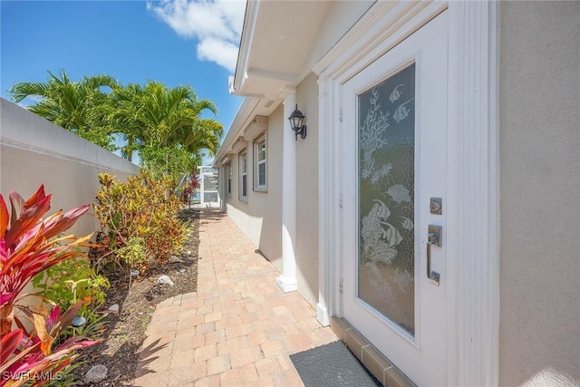 view of property exterior with stucco siding and fence