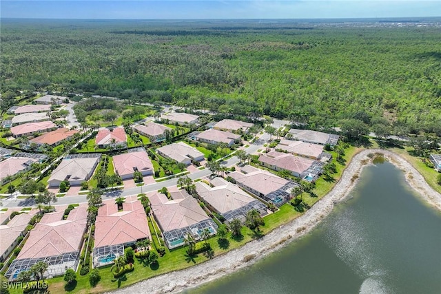 birds eye view of property featuring a water view, a residential view, and a forest view