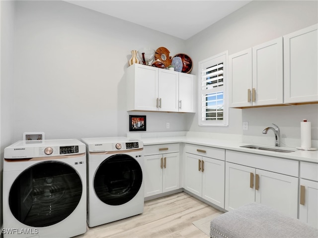 14243 Galley Ct, Naples, FL 34114 - washroom with cabinet space, separate washer and dryer, a sink, and light wood-type flooring