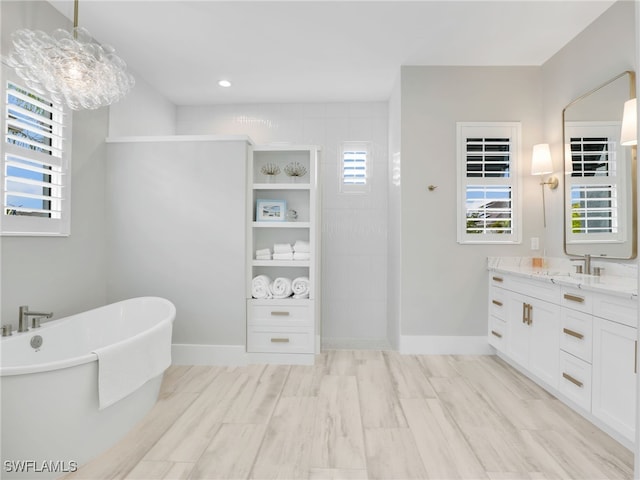 14243 Galley Ct, Naples, FL 34114 - bathroom with a walk in shower, a freestanding tub, baseboards, and vanity