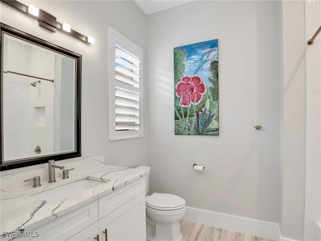 14243 Galley Ct, Naples, FL 34114 - bathroom featuring walk in shower, wood finished floors, vanity, baseboards, and toilet
