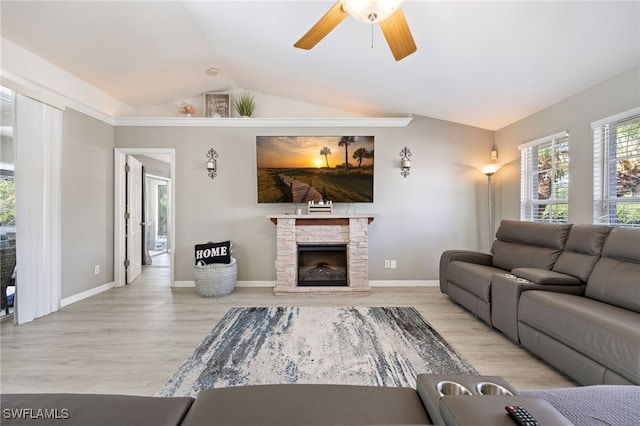 living room with vaulted ceiling, wood finished floors, ceiling fan, a fireplace, and baseboards