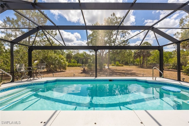 outdoor pool featuring view of scattered trees, a lanai, and a patio area