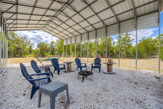 view of property's community with an outdoor fire pit and view of wooded area