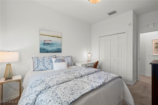 bedroom with baseboards, visible vents, a closet, and light colored carpet
