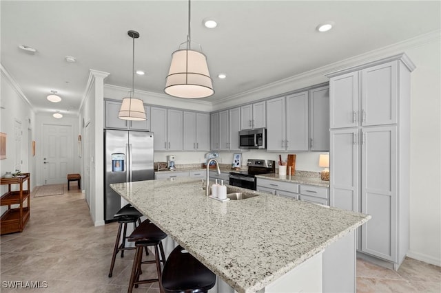kitchen featuring appliances with stainless steel finishes, ornamental molding, a sink, and a kitchen bar