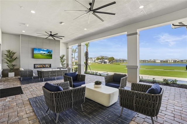 view of patio / terrace featuring a ceiling fan and an outdoor living space with a fireplace