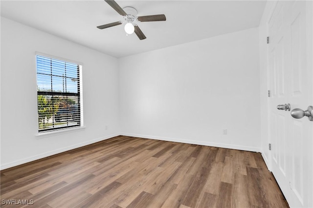 unfurnished room with wood finished floors, baseboards, and ceiling fan
